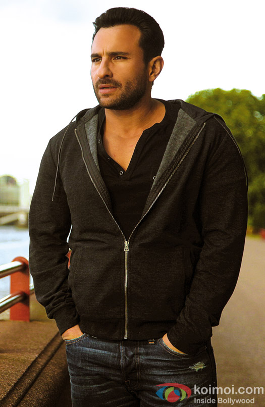 Saif Ali Khan glances away in a hooded grey jacket