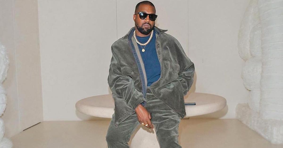 Kanye West leaving his office in a red and blue checkered jacket