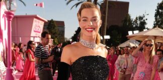 Margot Robbie Slays In A Cherry Printed White Shirt & Blue Denim With A Red Belt As She Recreates The Barbie Look